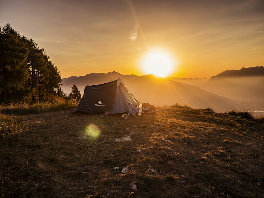 Dome tent on a mountaintop at sunset